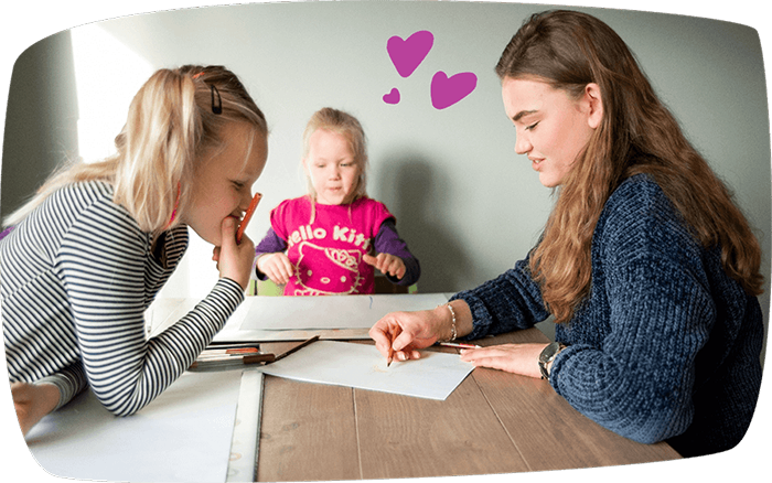 En barnevakt og barn som tegner sammen